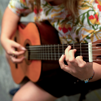 Integrante de agrupación musical ensayando con guitarra