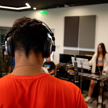 Estudiante con audifonos en sala de ensayo
